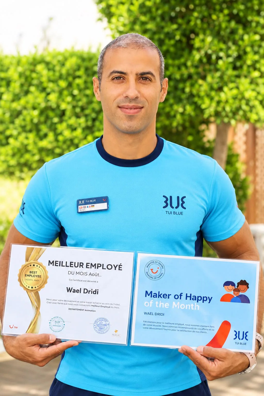Wael holding his TUI BLUE Best Employee of the Month and Maker of Happy awards