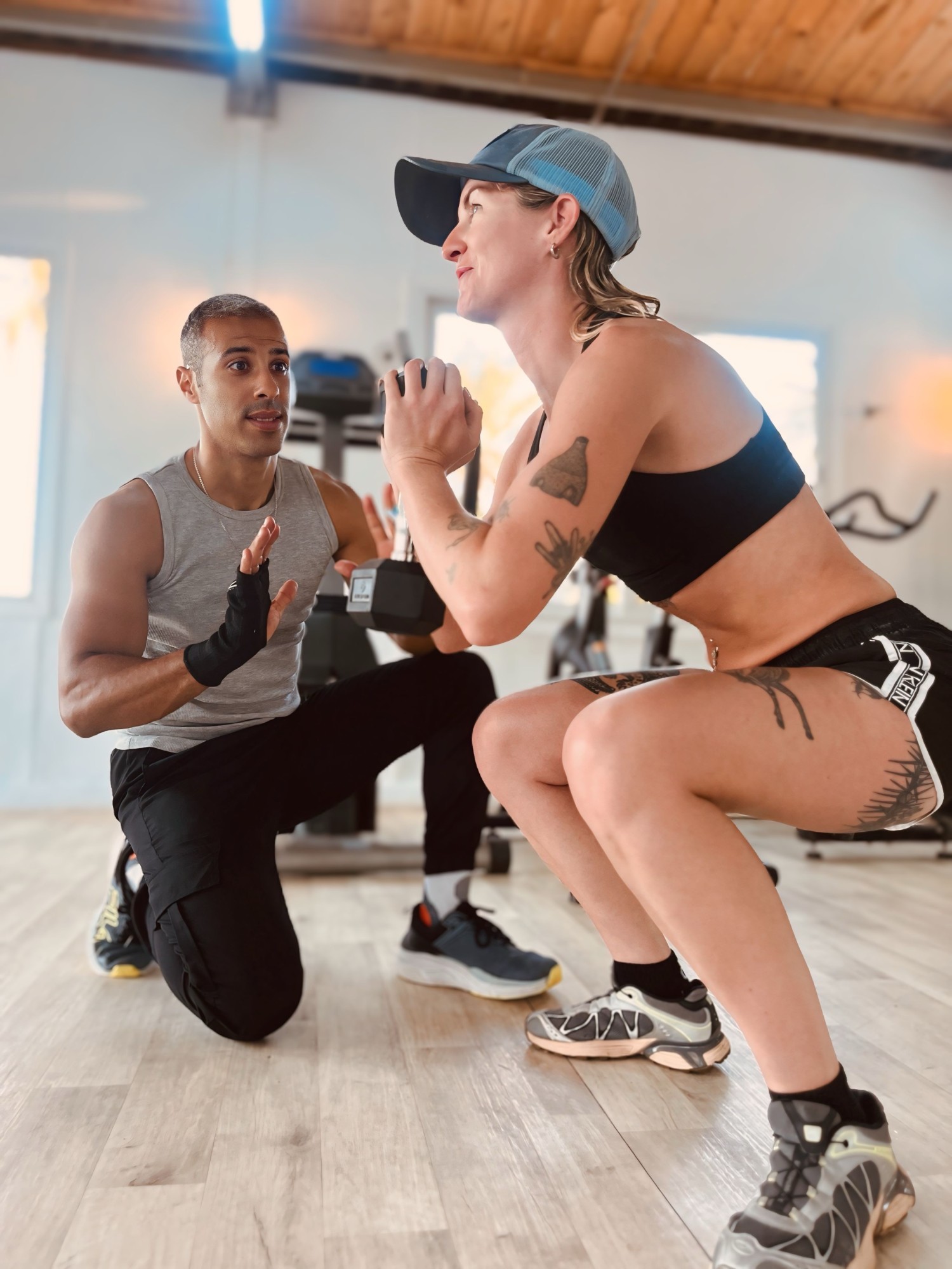 Coach Wael correcting a client's squat technique